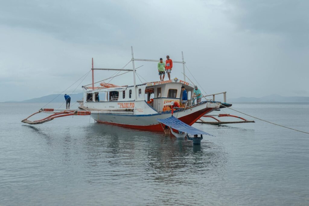 Boottrip in de Filipijnen met traditionele boot en lokale mensen op zee