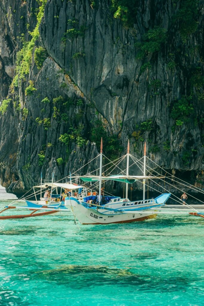 Eilandhoppen in El Nido, Palawan, met boten op helder turquoise water.