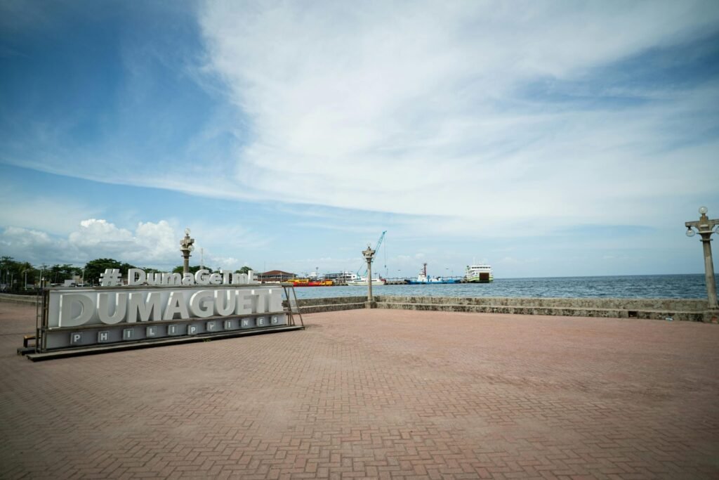 Uitzicht op de Dumaguete Boulevard met zee, haven en het Dumaguete-bord aan de kust van Negros Oriental.